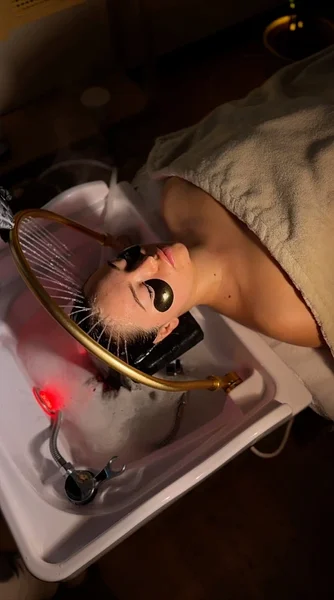 Klientka odpoczywająca na leżance podczas rytuału head spa w poznańskim salonie
